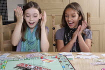 Children, Playing, Indoor, board games, two young girls playing Monopoly.