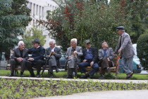 Albania, Tirane, Tirana, Group of elderly men and pensioners talking on a park bench.