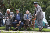 Albania, Tirane, Tirana, Group of elderly men and  pensioners talking on a park bench.