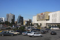 Albania, Tirane, Tirana, Traffic in Skanderbeg Square passing exterior facade of the National History Museum to the right.