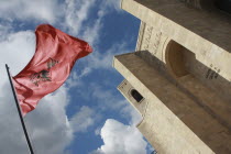 Albania, Kruja, National flag depicting black double headed eagle symbol on red background flying at the entrance to the Kruja Castle and Skanderbeg Museum.