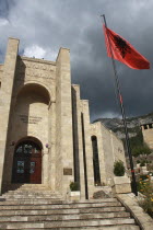 Albania, Kruja, Kruja Castle and Skanderbeg Museum, exterior facade with steps to entrance and National flag raised on flagpole at side.
