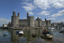 Wales, Gwynedd, Conway Castle seen across harbour with moored boats.