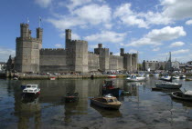 Wales, Gwynedd, Conway Castle seen across harbour with moored boats.