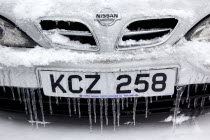 Weather, Winter, Ice, Melting snow and icicles on car fender and grill.