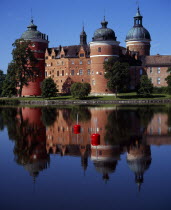 Sweden, Sodermanland, Mariefred, Gripsholm Castle beside Lake Malaren, red brick exterior with domed towers dating from sixteenth century.