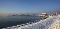 England, West Sussex, Shoreham-by-Sea, Mist rising from harbour waters on frosty morning with snow on the beach.