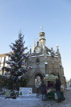 England, West Sussex, Chichester, the Cross and Christmas tree in snow with roast chestnut vendor.