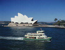 Australia, New South Wales, Sydney, Opera House with tourist boat in the harbour.
