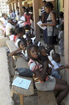 Haiti, La Gonave Island, Mothers with babies waiting to be vaccinated by the Scottish Charity LemonAid who help support the people with health care, clean water programs and giving goats to families.