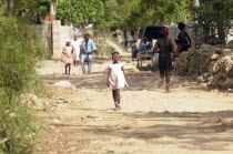 Haiti, La Gonave Island, Young girl walking along dirt track.