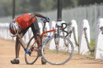 India, Delhi, 2010 Commonwealth games, Road cycling event competitor checking gears on his bike.