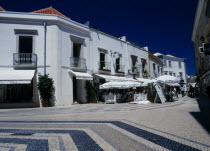 Portugal, Algarve, Faro, Main shopping area with white washed buildgin and colourfully decorated pavement.