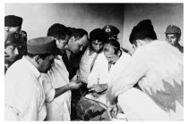 Bolivia, Santa Cruz, Vallegrande, Two Bolivian doctors prepare to insert tube draining formalin from an enamel mug into the neck of the body of Ernesto Che Guervara. The CIA agent Gustavo Villoldo ali...