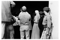 Bolivia, Santa Cruz, Vallegrande, Onlookers at the doorway of the laundry room of the local Vallegrande hospital where the body of Che Guevara had been taken for inspection. Monday 09 October 1967.