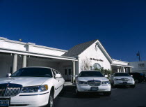 USA, Nevada, Las Vegas, The Little Chapel of the Flowers wedding chapel on the strip with three white limousines outside.