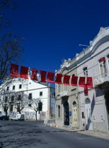 Portugal, Algarve, Faro, tyrpical street scene with red banners stretched across the road.