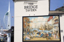 England, Hampshire, Portsmouth, The Camber in Old Portsmouth showing the Spinnaker Tower beyond the Bridge Tavern with a mural by Thomas Rowlanson of his cartoon entitled Portsmouth Point.