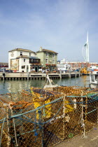 England, Hampshire, Portsmouth, The Camber in Old Portsmouth showing the Spinnaker Tower beyond the Bridge Tavern with a mural by Thomas Rowlanson of his cartoon entitled Portsmouth Point with fishing...