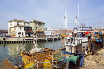 England, Hampshire, Portsmouth, The Camber in Old Portsmouth showing the Spinnaker Tower beyond the Bridge Tavern with a mural by Thomas Rowlanson of his cartoon entitled Portsmouth Point with fishing...