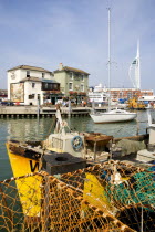 England, Hampshire, Portsmouth, The Camber in Old Portsmouth showing the Spinnaker Tower beyond the Bridge Tavern with a mural by Thomas Rowlanson of his cartoon entitled Portsmouth Point with fishing...