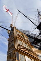 England, Hampshire, Portsmouth, Historic Naval Dockyard HMS Victory the Flagship of Admiral Lord Nelson showing the stern with the Royal Navy White Ensign flag flying from the quarter deck.
