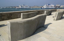 ENGLAND, Hampshire, Portsmouth, Seating on the Millenium Walk with Yachts and Isle of Whight car ferries entering and leaving the harbour between and HMS Dolphin in Gosport on the far side of the entr...