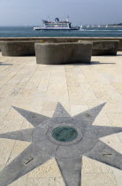 ENGLAND, Hampshire, Portsmouth, Compass plaque on the Millenium Walk commemorating its opening by Prince Phillip The Duke of Edinburgh with Yachts and Isle of Whight car ferry entering and leaving the...