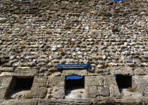 England, Hampshire, Portsmouth, Portchester Castle Norman 12th Century flint walls rebuilt on the site of the Roman 3rd Century Saxon Shore Fort with the garderobe chutes or toilets from the Augustine...