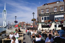 ENGLAND, Hampshire, Portsmouth, Harbour with the 170 metre tall Spinnaker Tower seen from the Spice Island Inn public house with people sitting at tables in Bath Square outside the pub.