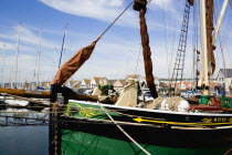 England, Hampshire, Portsmouth, Port Solent Sailing barge SB Kitty moored in the marina with yachts and housing beyond.