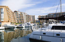 ENGLAND, Hampshire, Portsmouth, Port Solent with boats moored in the Marina surrounded by apartment buildings.