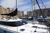 England, Hampshire, Portsmouth, Port Solent Yachts moored in the marina with apartment buildings beyond.