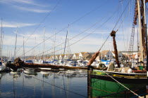 England, Hampshire, Portsmouth, Port Solent Sailing barge SB Kitty moored in the marina with yachts and housing beyond.