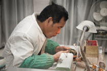 China, Beijing, Man manufacturing a jade ornament in a jade factory.