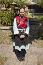 China, Yunnan Province, Baisha, Young Naxi woman wearing traditional costume.