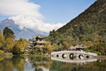 China, Yunnan Province, Lijiangf, Black Dragon Pool and Deyue Pavilion with the Jade Dragon Snow Mountain behind.