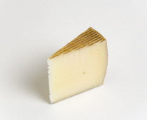 Food, Dairy Product, Cheeses, Slice of Spanish Manchego cheese made from pasteurised Manchega sheep's milk from the La Mancha region of Spain against a white background.