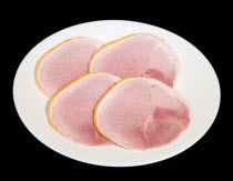 Food, Meat, Pork, Slices of cured ham on a round white plate on a black background.