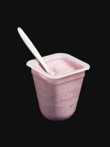 Food, Organic, Yogurt, Yeo Valley probiotic blueberry fruit yogurt with spoon in pot against a black background.