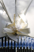 Religion, Christian, Weddings, Cream ribbon tied in bow on bonnet of vintage white Daimler wedding car.