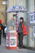 Scotland, Strathclyde, Glasgow, Pipe smoking Evening Times newspaper street vendor.