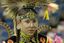 Canada, Alberta, Lethbridge, International Peace Pow Wow, Head shot of Blackfoot Indian dancer with feather headdress bead work headband and string of beads across face.