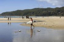 Australia, New South Wales, Byron Bay, young surfer walking toward the sea.