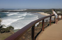 Australia, Queensland, Gold Coast, Coolangatta, tourist overlooking bay and beach from headland viewpoint.