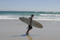 Australia, Queensland, Gold, Coast, Coolangatta, surfer walking toward the sea.