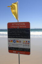 Australia, Queensland, Gold Coast, Coolangatta, Beach lifeguard yellow flag and warning sign.