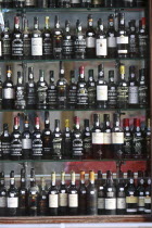 Portugal, Lisbon, Display of port bottles in a shop front window.