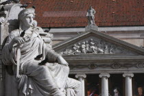 Portugal, Lisbon, Carving at the foot of the statue of Dom Pedro IV in Praca Rossio Square with Teatro Nacional Dona Maria II Opera House in the background.