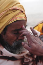 India, Uttarakhand, Hardiwar, Head and shoulders portrait of pilgrim having tilak mark applied to his forehead to indicate spiritual devotion during Kumbh Mela, Indias biggest religious festival where...